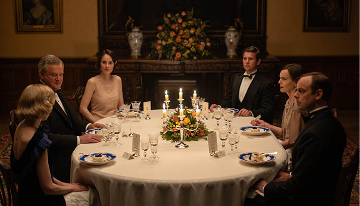 Menschen sitzen um einen gedeckten Tisch