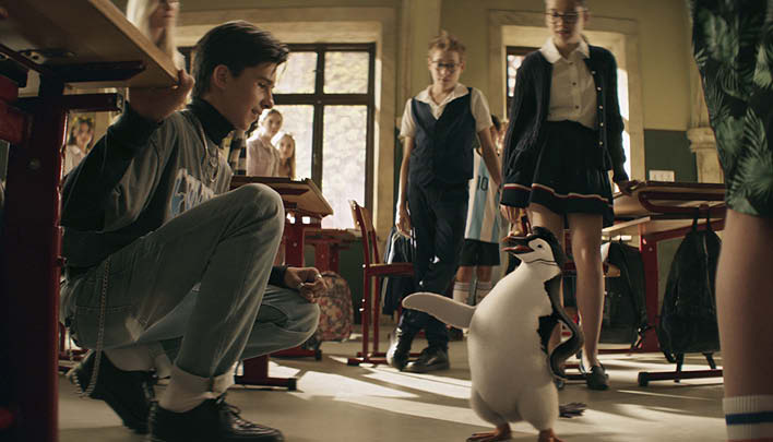 Junge mit Pinguin in Klassenzimmer