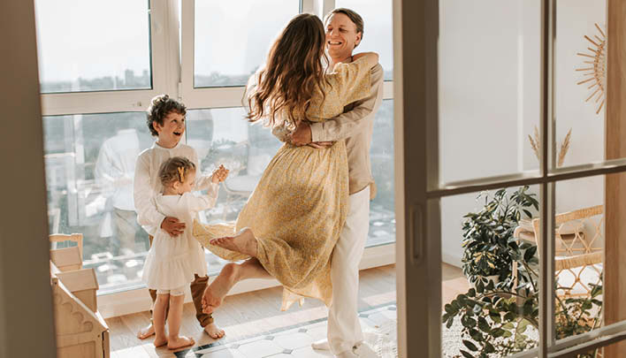 Familie in Wohnung und die Mutter umarmt den Vater