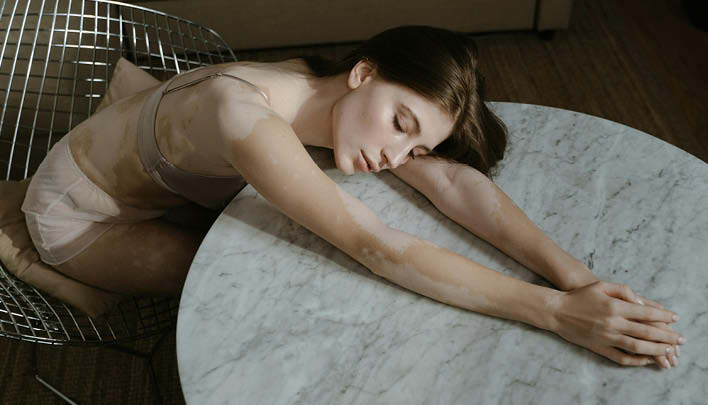 Frau lehnt über Marmortisch