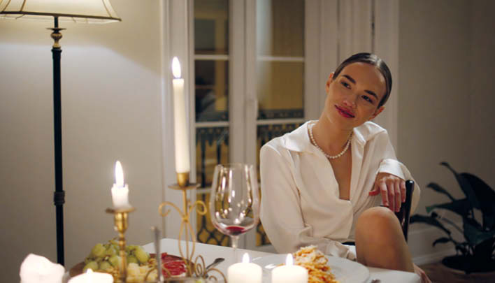 Frau sitzt an einem romantisch gedeckten Tisch
