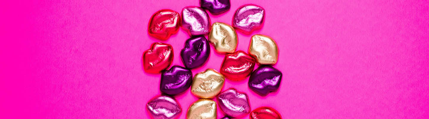 pinker Hintergrund mit kleinen, künstlichen Lippen in bunt