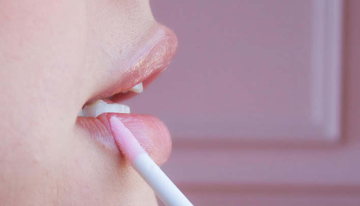 Frau benutzt Lipgloss