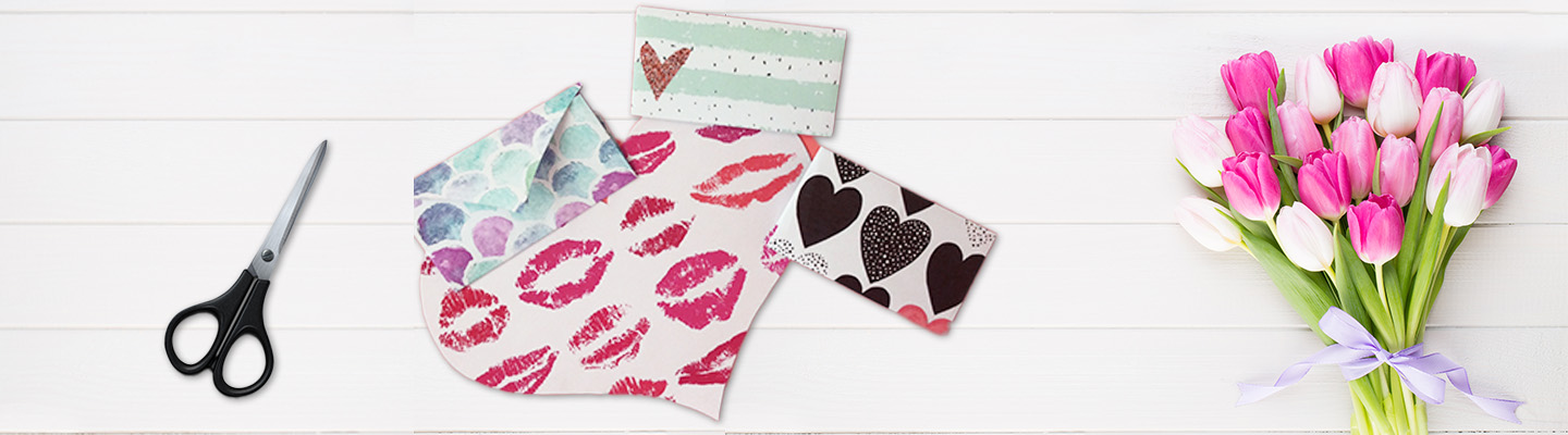 Fertig gestaltete Muttertagskarten mit verschiedenen Motiven auf weißem Hintergrund, rechts davon ein Tulpen-Blumenstrauß und links davon eine Schere