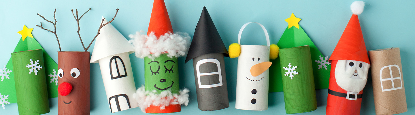 Verschiedene weihnachtliche Figuren aus leeren Toilettenrollen vor einem hellblauen Hintergrund