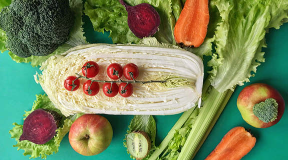 lifestyle-flatlay-brokkoli-rote-beete-aepfel-cocktailtomaten-kiwi-sellerie-moehren-salat-kohl-gruener-hintergrund-575x320-92282-0