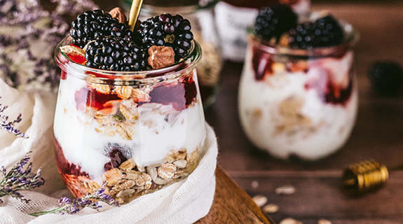 lifestyle-holz-weisses-kleine-muesliglaeser-mit-granola-joghurt-und-brombeeren-575x320-90549-0