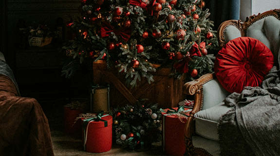 lifestyle-h4-festliches-dunkelgru-ene-wand-zimmer-spiegel-weihnachtsbaum-rote-kugeln-geschenke-sessel-holzboden-06-24-102159-0