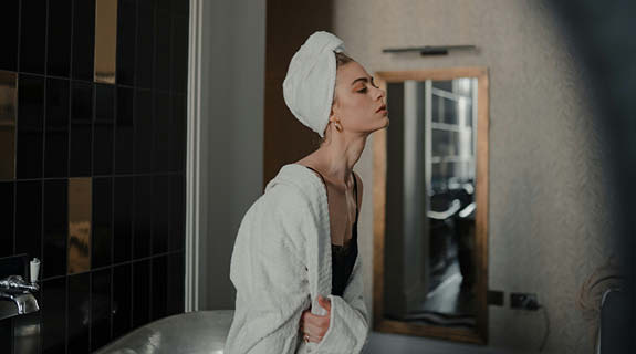lifestyle-junge-frau-im-bademantel-badezimmer-575x320-92051-0