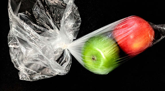 lifestyle-roter-und-gruener-apfel-in-transparenter-plastiktuete-schwarzer-hintergrund-575x320-90713-0