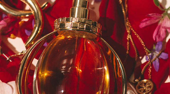 lifestyle-runder-parfumflakon-auf-rosenblaettern-goldener-schmuck-01-25-104478-0