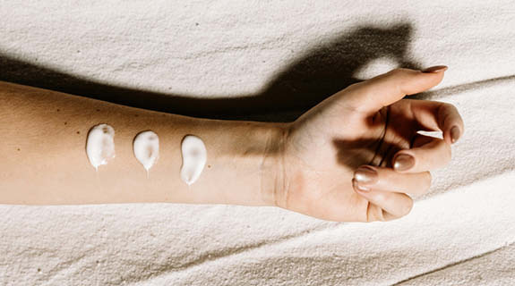 lifestyle-frauenunterarm-hand-goldener-nagellack-creme-beiger-stoff-hintergrund-04-24-96574-1