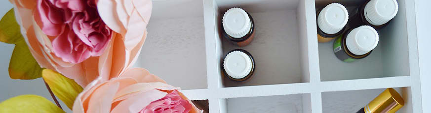 lifestyle-weisse-holzkiste-mit-aromaoelflaeschchen-pfingstrosen-heller-hintergrund-873x230-92221-1