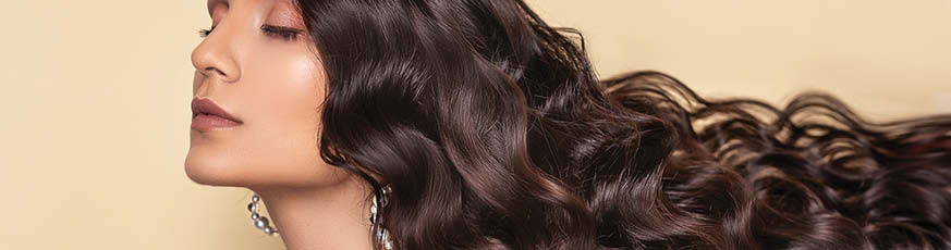 lifestyle-dunkelhaarige-frau-geschlossene-augen-lange-wellige-haare-873x230-90672-0