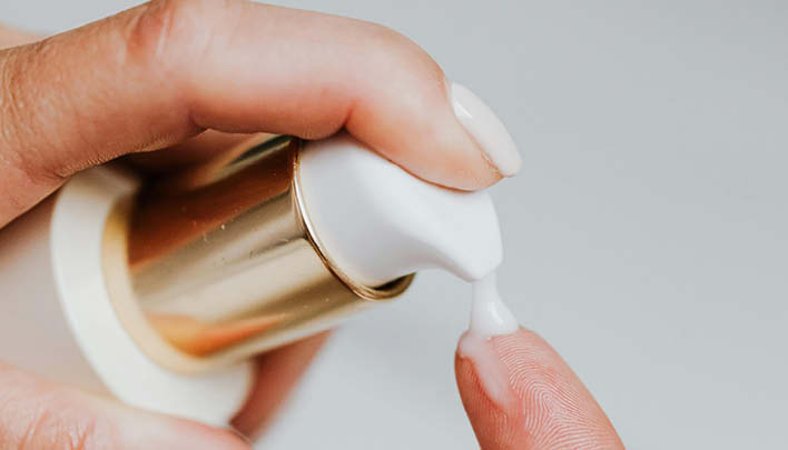 Creme, die auf Finger aufgetragen wird