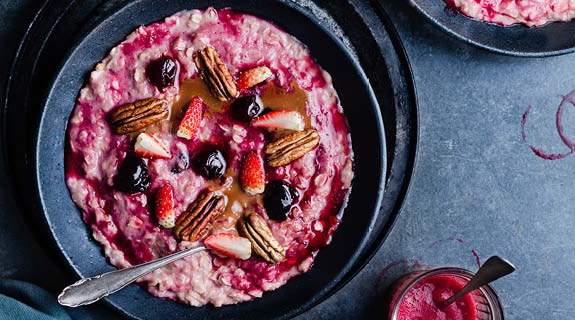 lifestyle-dunkles-geschirr-birchermuesli-mit-heidelbeeren-erdbeeren-und-pekanuessen-graublauer-untergrund-575x320-90551-0