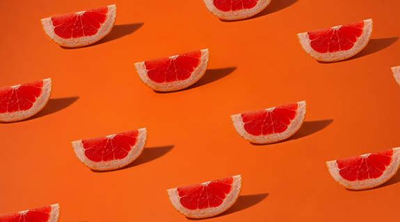 lifestyle-grapefruitschnitze-oranger-hintergrund-04-24-96433-0