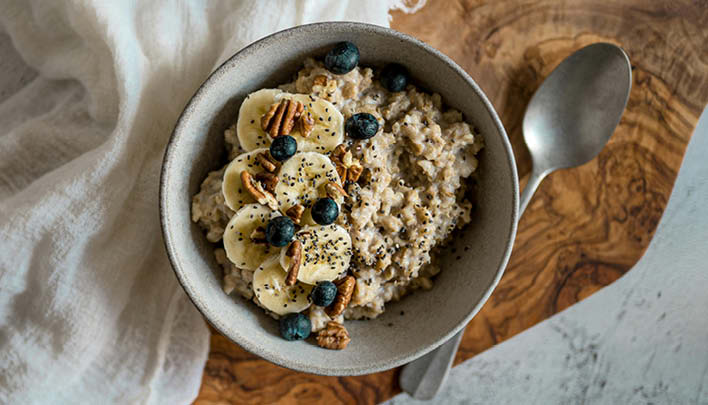 Lifestyle_708x405_Porridge_Banane_Blaubeeren_Walnüsse_Löffel_Holzbrett_weisses_Tuch_weisser_Hintergrund_2_26