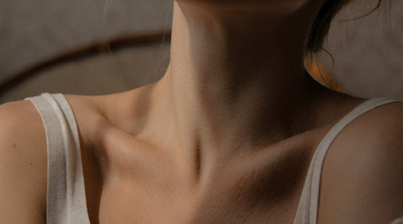 lifestyle-ausschnitt-frau-schlu-esselbein-wei-es-top-grauer-hintergrund-575x320-98524-0