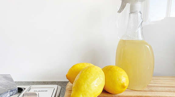 lifestyle-zitronen-tischplatte-spruehflasche-mit-gelber-fluessigkeit-575x320-90588-0