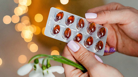 lifestyle-frauenha-ende-rosa-nagellack-tablettenblister-maiglo-eckchen-lichtreflexe-im-hintergrund-575x320-98473-0