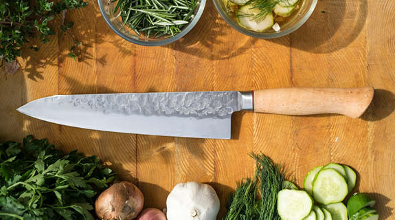 lifestyle-holzplatte-mit-messer-petersilie-zweibeln-knoblauch-dill-gurken-majoran-schalen-mit-rosmarin-kraeuter-575x320-92296-0