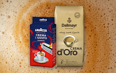Lavazza und Dallmayr Kaffeepackungen vor Kaffeeschaum-Hintergrund