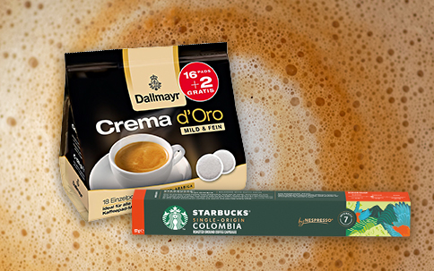 Dallmayr Kaffeepads und Starbucks Kaffeekapseln vor Kaffeeschaum