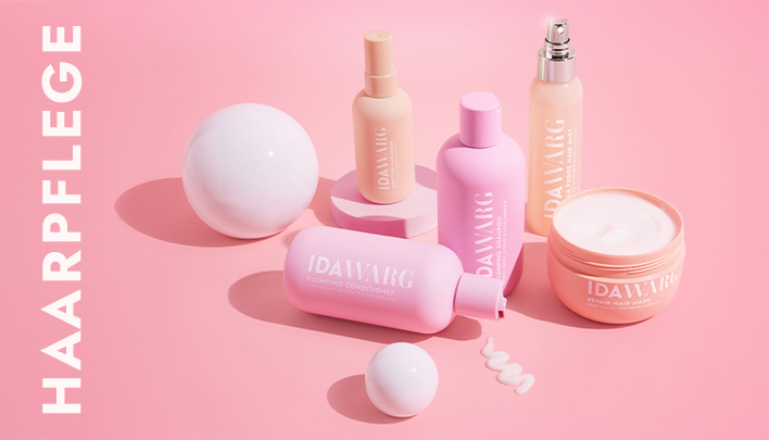 Ida‑Warg‑Haarpflegeprodukte in Pastellfarben auf rosa Hintergrund arrangiert