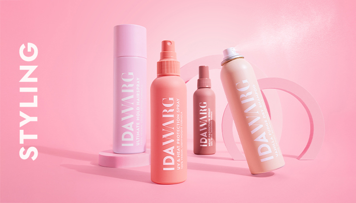 Ida‑Warg‑Beauty Produkte in Pastellfarben vor rosa Hintergrund arrangiert