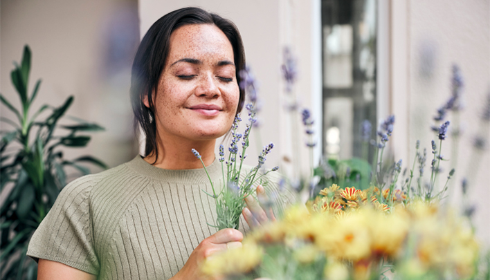 Person hält einen Strauß aus Lavendel und Blumen im Gartenbereich