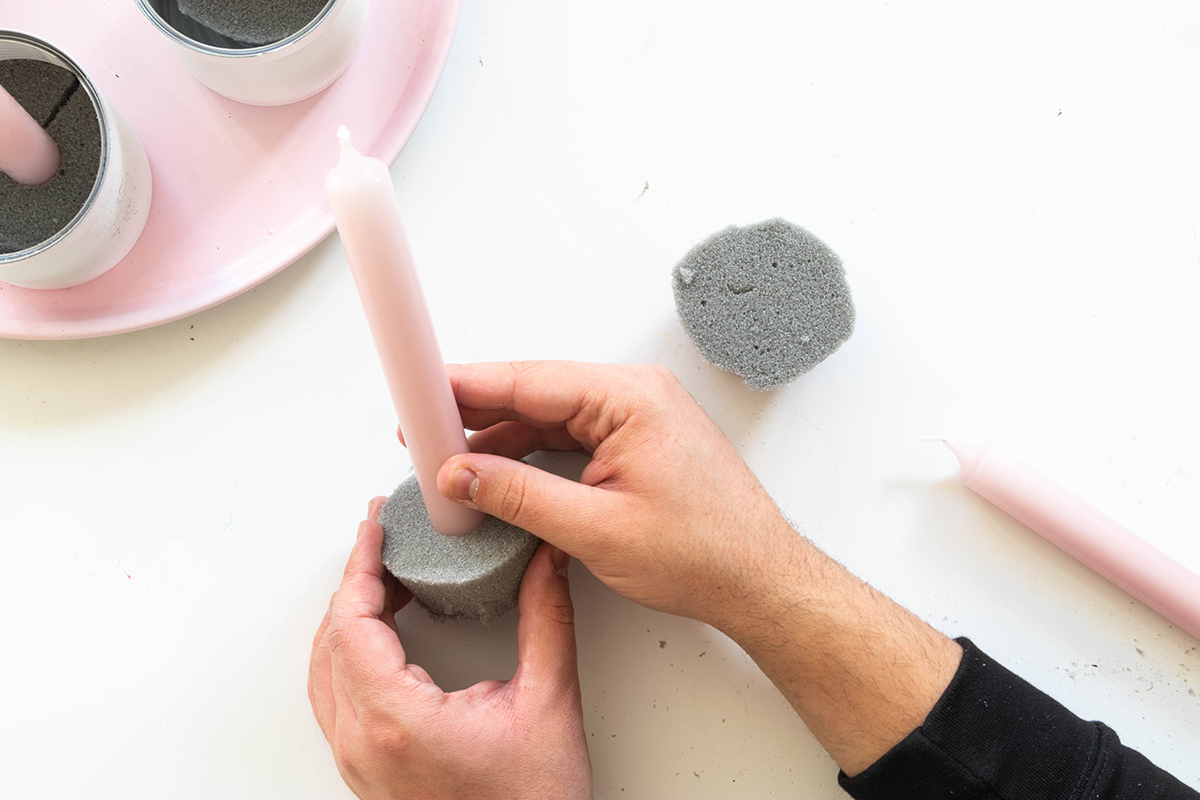 Bild: Hand steckt Kerze in Schaumstoff