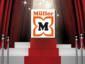 Logo Müller vystavené na pódiu so svetlami reflektorov ako symbol firemných úspechov.