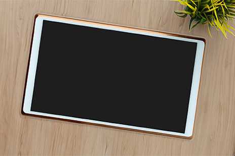 Tablet položený na drevenom stole.