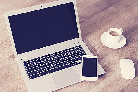 Notebook, smartfón na drevenom stole.